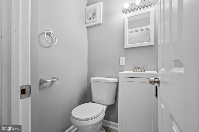 bathroom featuring vanity, toilet, and baseboards