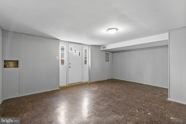 basement featuring tile patterned floors, electric panel, and visible vents