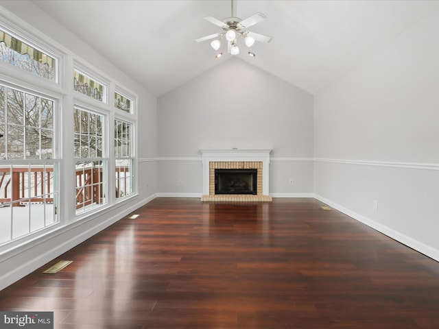 unfurnished living room with lofted ceiling, a fireplace, baseboards, and dark wood finished floors