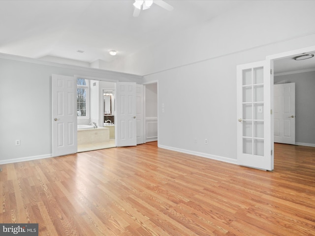 spare room with light wood-type flooring, ceiling fan, and baseboards