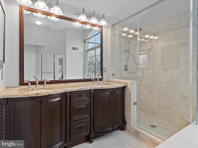 full bath with visible vents, a sink, a shower stall, and double vanity