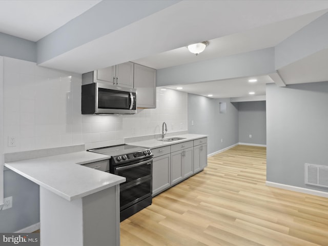 kitchen with gray cabinetry, a sink, visible vents, light countertops, and appliances with stainless steel finishes