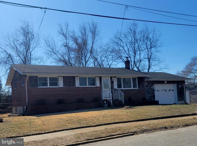 ranch-style house with brick siding, a chimney, an attached garage, and a front yard