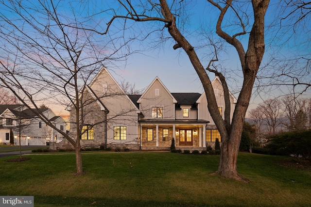 view of front of property featuring a front yard, covered porch, metal roof, and a standing seam roof