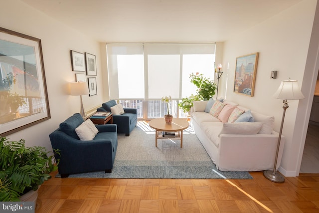 living area with baseboards and floor to ceiling windows