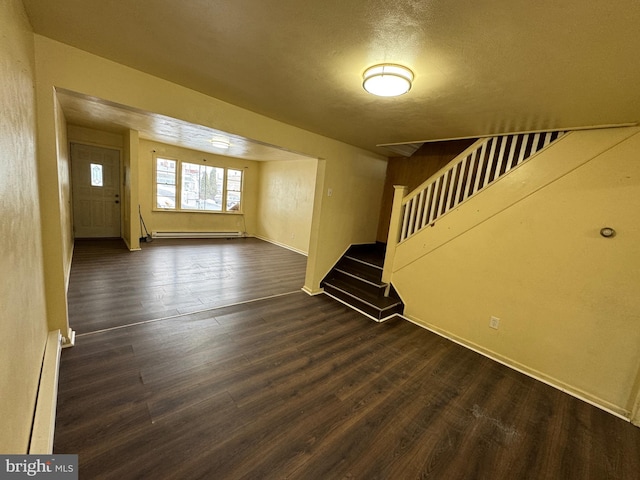 unfurnished living room featuring stairway, baseboards, a baseboard heating unit, and dark wood-type flooring