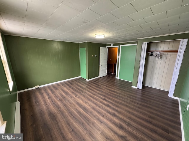 unfurnished bedroom with dark wood-style flooring and baseboards