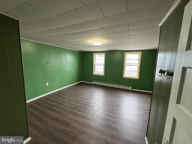 empty room featuring dark wood-style floors, baseboards, and baseboard heating