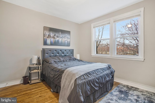 bedroom featuring baseboards and wood finished floors