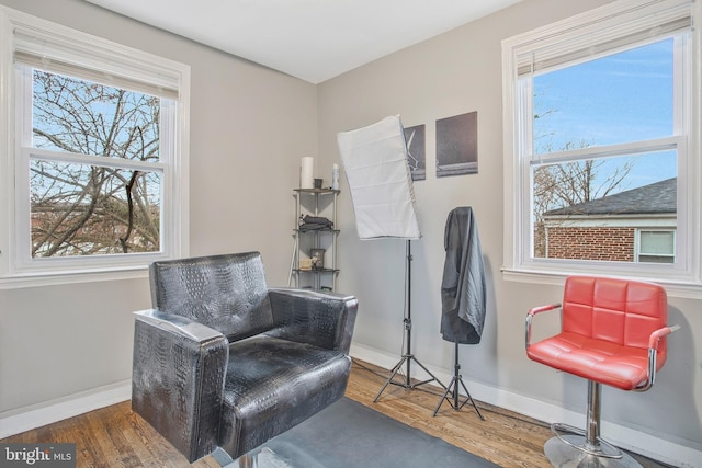 sitting room with baseboards and wood finished floors