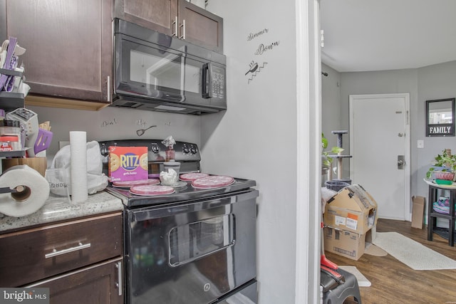 kitchen featuring dark brown cabinets, black appliances, and wood finished floors