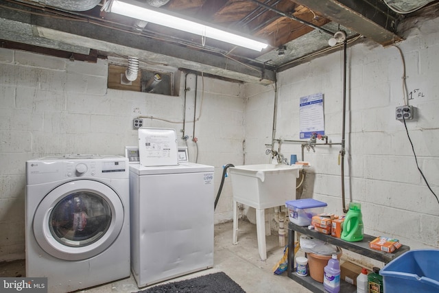 washroom with laundry area, a sink, and washer and clothes dryer