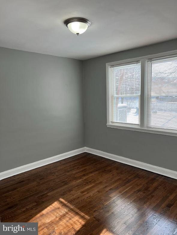 unfurnished room featuring dark wood finished floors and baseboards