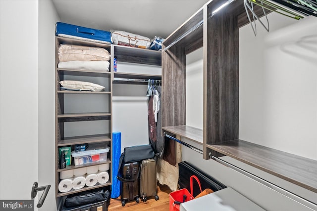 walk in closet with wood finished floors