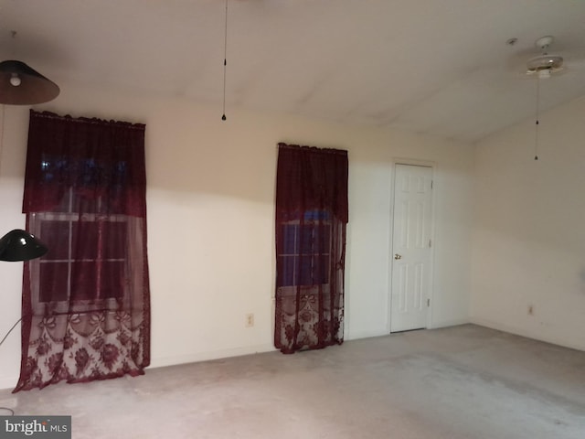 carpeted empty room with vaulted ceiling