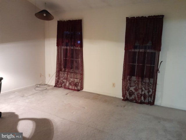 unfurnished room featuring carpet floors and baseboards