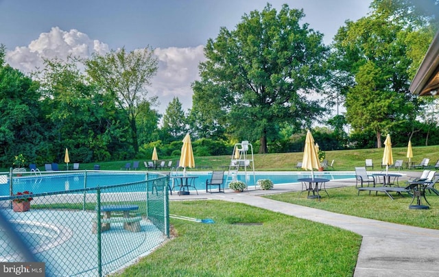 pool featuring fence and a yard