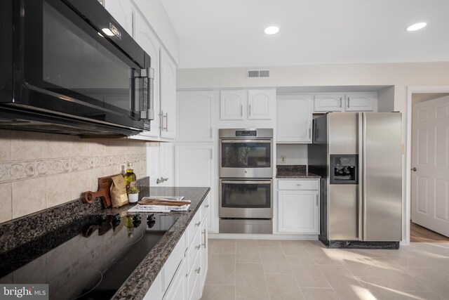 kitchen with tasteful backsplash, visible vents, black appliances, dark stone counters, and white cabinetry