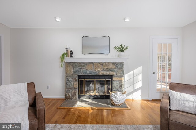 living area with a fireplace, recessed lighting, wood finished floors, and baseboards