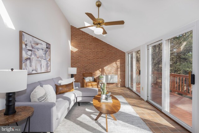 living room featuring brick wall, a ceiling fan, and vaulted ceiling