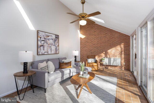 tiled living area featuring vaulted ceiling with skylight and a ceiling fan