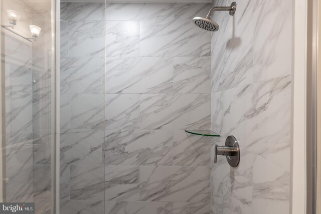 interior details featuring a marble finish shower