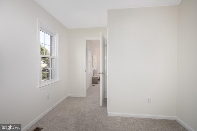 carpeted empty room with baseboards