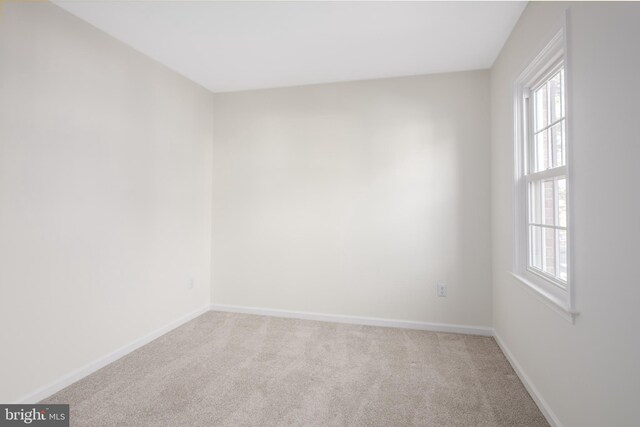 unfurnished room featuring baseboards and carpet