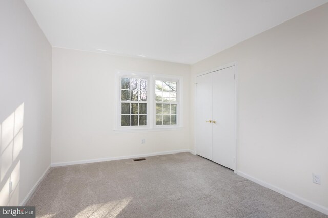 carpeted spare room with baseboards and visible vents