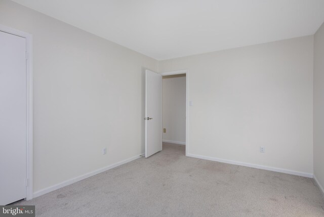 carpeted empty room with baseboards