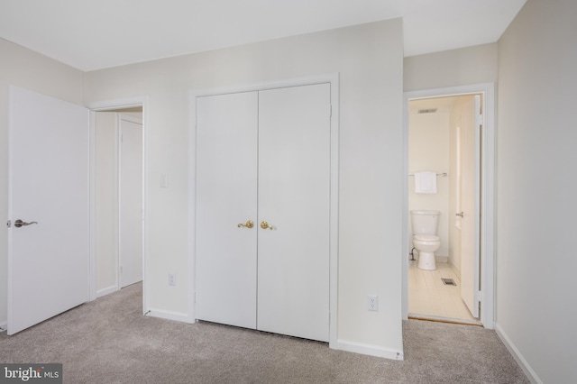 unfurnished bedroom featuring baseboards, a closet, carpet floors, and visible vents