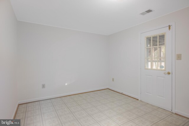 empty room with visible vents, light floors, and baseboards