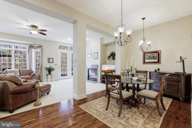 dining area featuring recessed lighting, a ceiling fan, a glass covered fireplace, wood finished floors, and baseboards