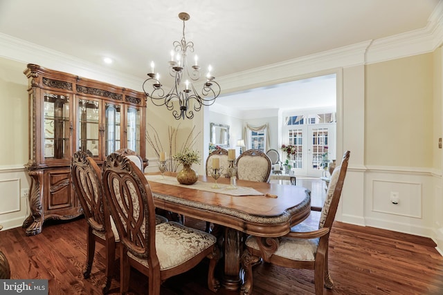 dining room with dark wood-style floors, ornamental molding, and a decorative wall