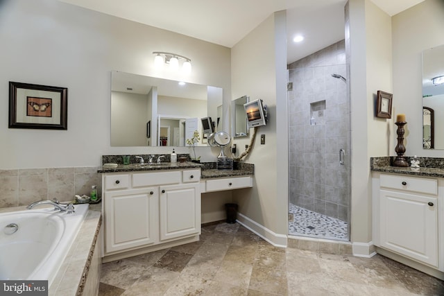 full bathroom with a garden tub, a shower stall, baseboards, and vanity