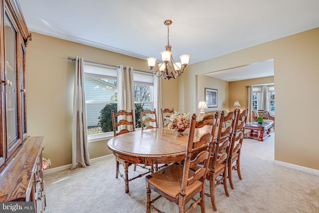 dining area with an inviting chandelier, light colored carpet, baseboards, and a wealth of natural light