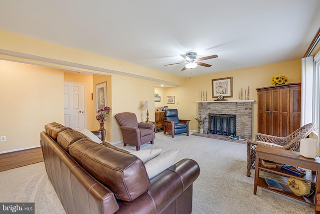 living room featuring carpet flooring, ceiling fan, a brick fireplace, and baseboards