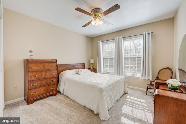 bedroom with a ceiling fan, light colored carpet, and baseboards