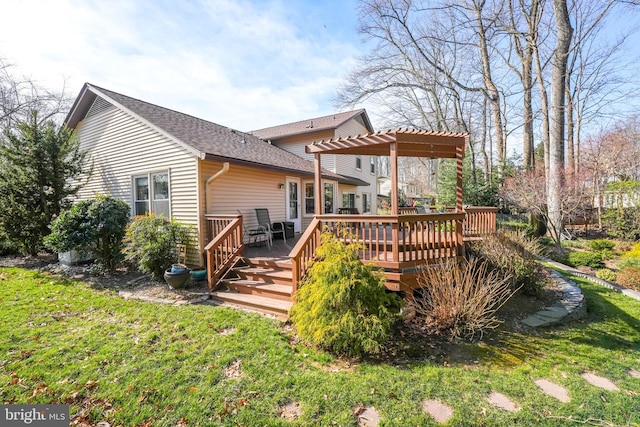 rear view of property featuring a wooden deck, a lawn, a pergola, and a shingled roof