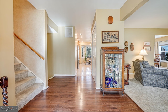 interior space with visible vents, stairway, baseboards, and hardwood / wood-style floors