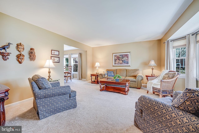 carpeted living room with baseboards