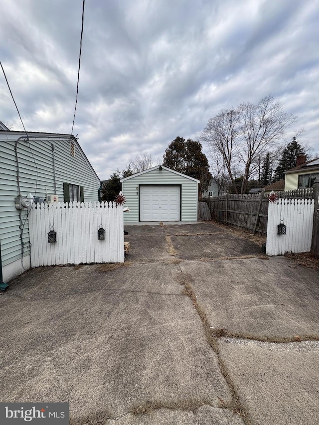 detached garage with driveway and fence