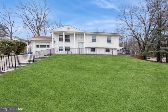 split foyer home featuring an attached garage, fence, and a front lawn