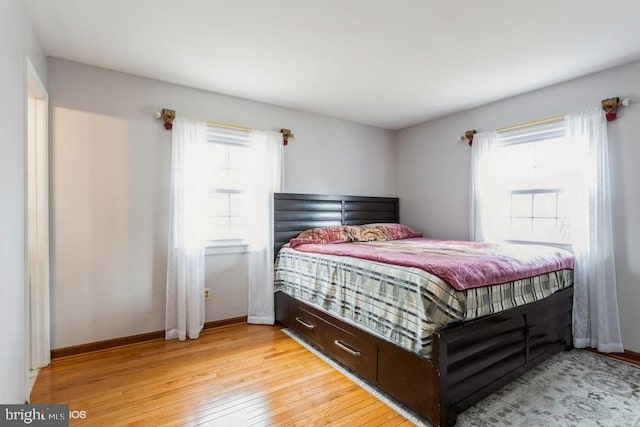 bedroom featuring light wood finished floors and baseboards