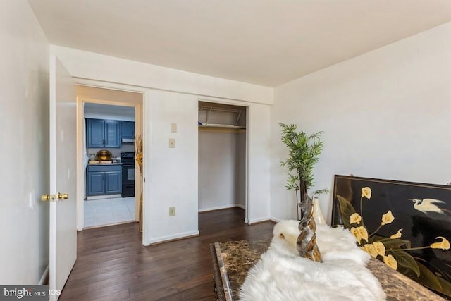 bedroom featuring a closet, baseboards, and dark wood-type flooring