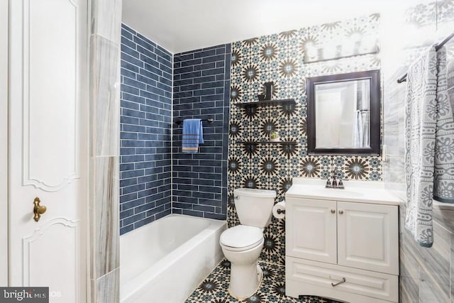 bathroom featuring toilet, tub / shower combination, tile walls, and vanity