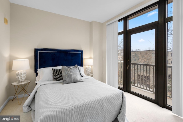 carpeted bedroom with access to outside and baseboards