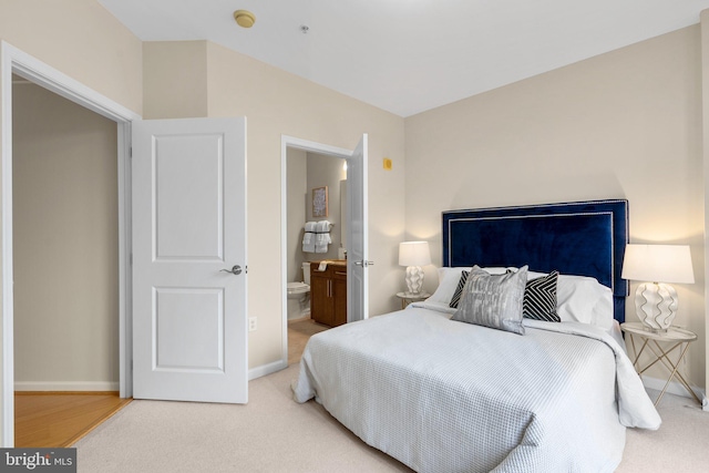 bedroom with carpet floors, connected bathroom, and baseboards