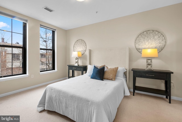 bedroom featuring light carpet, baseboards, and visible vents