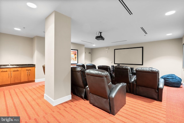 home theater with recessed lighting, light carpet, a sink, visible vents, and baseboards